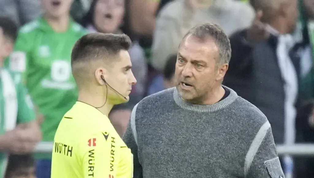 Hansi Flick conversando com o bandeirinha na partida entre Real Betis v Barcelona (IMAGO / NurPhoto)