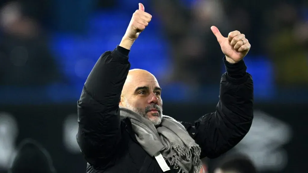 Pep Guardiola, de casaco preto, em campo, pelo Manchester City (Photo by Justin Setterfield/Getty Images)