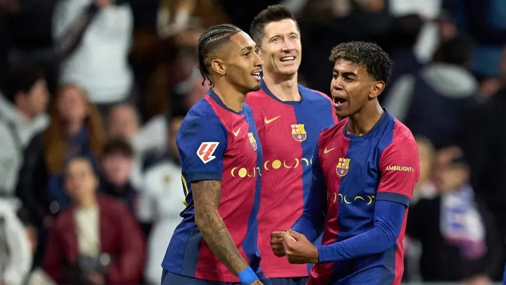 Raphinha, do FC Barcelona, comemora o quarto gol de sua equipe com os companheiros Robert Lewandowski e Lamine Yamal durante a partida da LaLiga entre Real Madrid CF e FC Barcelona no Estádio Santiago Bernabéu, em 26 de outubro de 2024, em Madri, Espanha. (Foto: Angel Martinez/Getty Images)