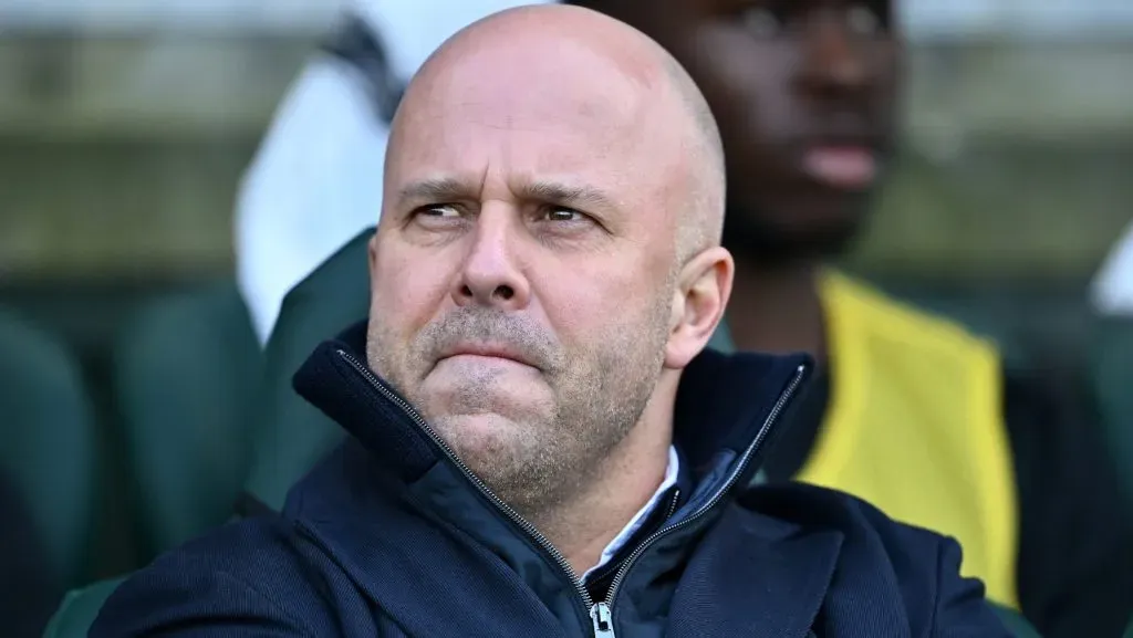 Arne Slot, sentado, de jaqueta preta, pelo Liverpool. (Photo by Dan Mullan/Getty Images)