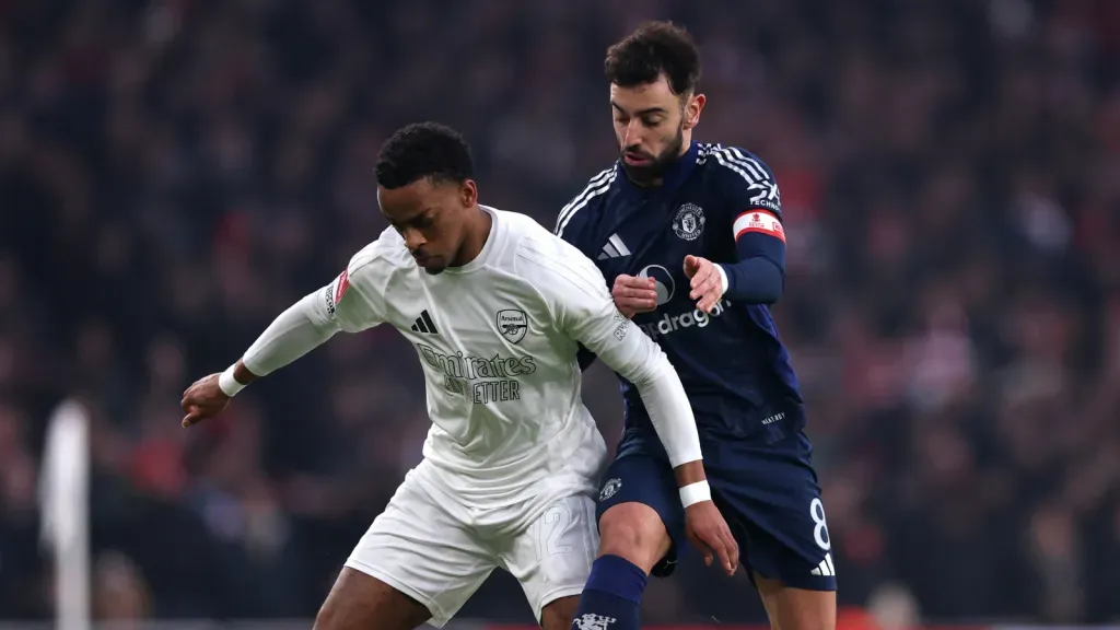 Jurrien Timber e Bruno Fernandes disputando a bola em jogo (Photo by Julian Finney/Getty Images)