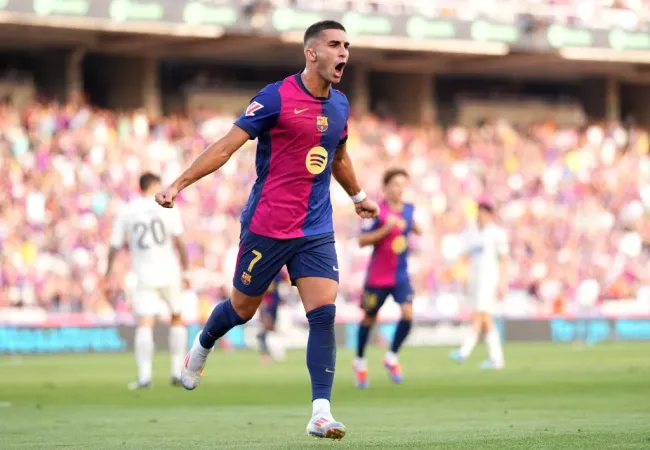 Ferrán Torres, com braços abertos, em campo, com a camisa vinho e azul do Barcelona