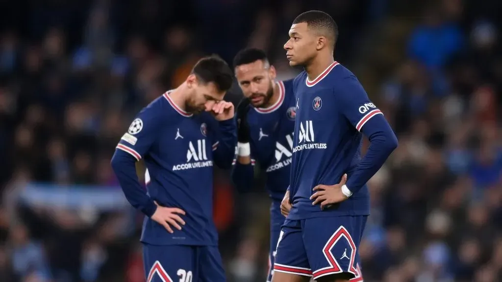 Kylian Mbappé, do Paris Saint-Germain, reage enquanto seus companheiros de equipe Lionel Messi e Neymar conversam ao fundo após o primeiro gol do Manchester City durante a partida do grupo A da UEFA Champions League entre Manchester City e Paris Saint-Germain no Etihad Stadium, em 24 de novembro de 2021, em Manchester, Inglaterra. (Foto por Laurence Griffiths/Getty Images)