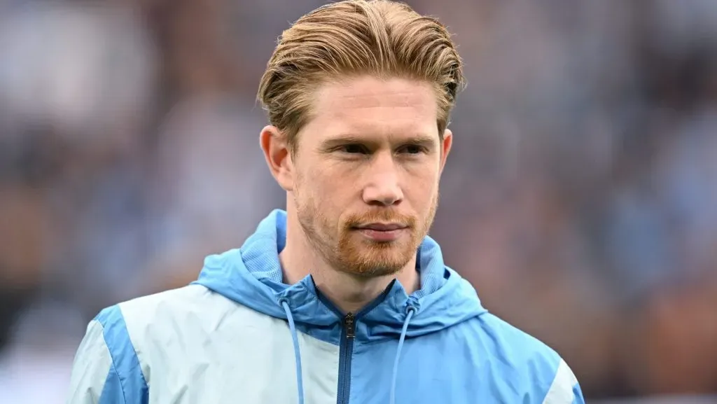 Kevin De Bruyne, em campo, com a jaqueta azul do Manchester City. (Photo by Michael Regan/Getty Images)