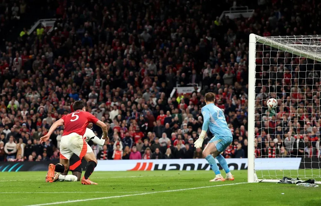 Harry Maguire, do Manchester United, marca o quinto gol de sua equipe diante de Lucas Perri, do Olympique Lyonnais, durante a partida de volta das quartas de final da UEFA Europa League 2024/25, realizada em Old Trafford no dia 17 de abril de 2025, em Manchester, Inglaterra. (Foto de Carl Recine/Getty Images)