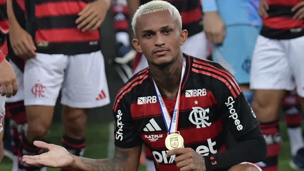 Wesley, jogador do Flamengo, no chão, com medalha no pescoço. . Foto: Thiago Ribeiro/AGIF