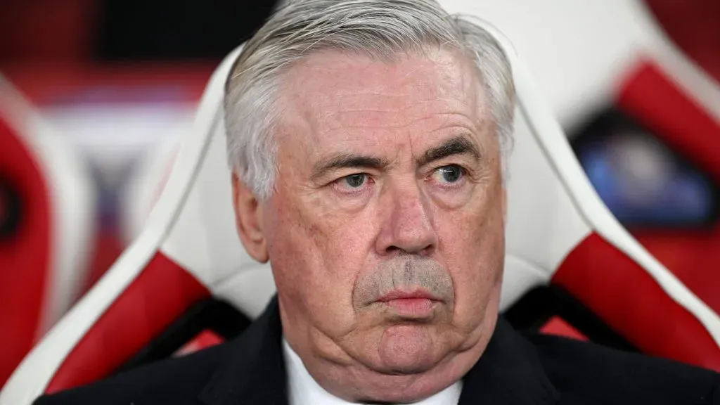 Ancelotti, sentado no banco de reservas, de terno preto, no Real Madrid (Photo by Justin Setterfield/Getty Images)