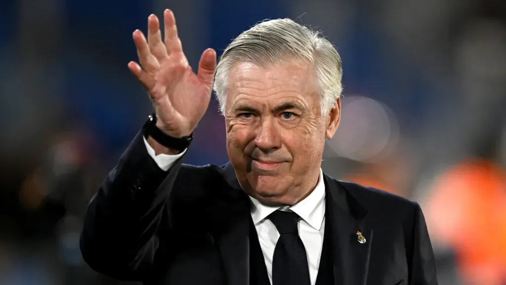 Carlo Ancelotti, de terno, com uma mão para o alto, durante partida pelo Real Madrid (Photo by Denis Doyle/Getty Images)
