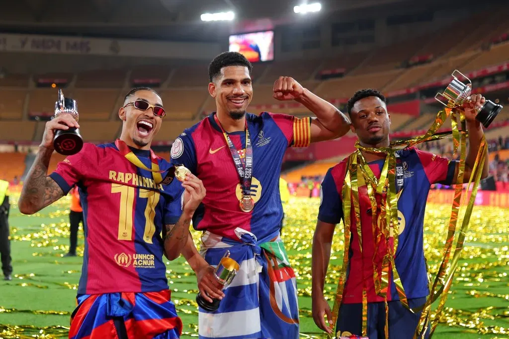 Raphinha, de óculos, e a camisa vermelha e azul do Barcelona (Photo by Fran Santiago/Getty Images)