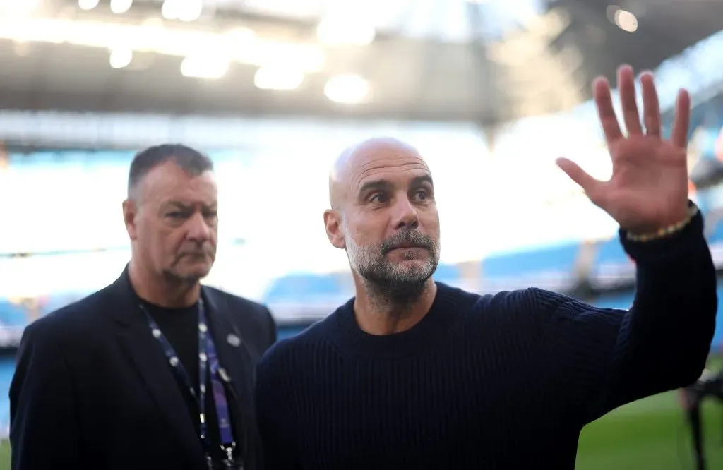 Guardiola, em campo no Etihad, de suéter preto, pelo Manchester City