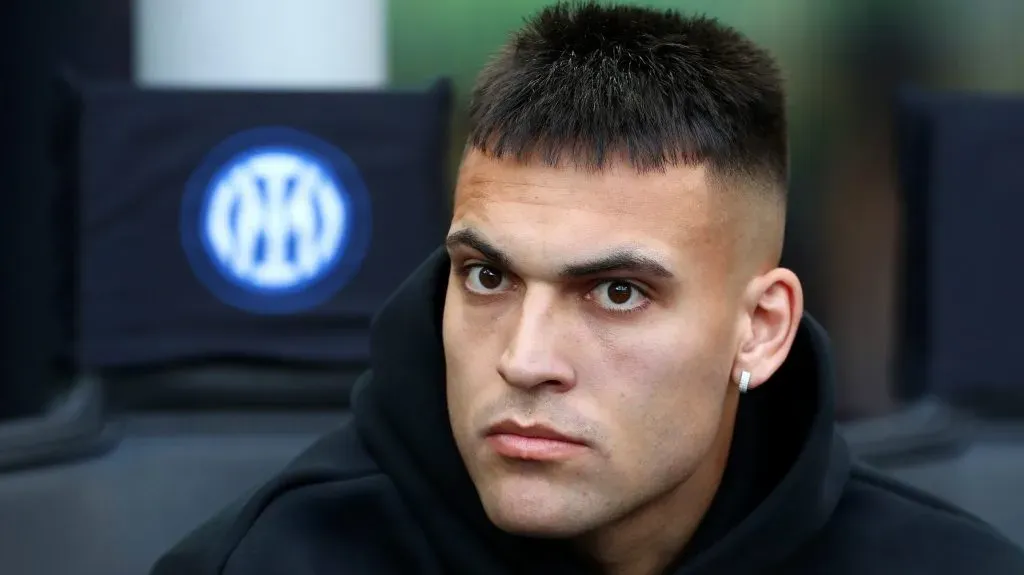 Lautaro Martínez, de moletom preto, sentado no banco de reservas (Photo by Marco Luzzani/Getty Images)