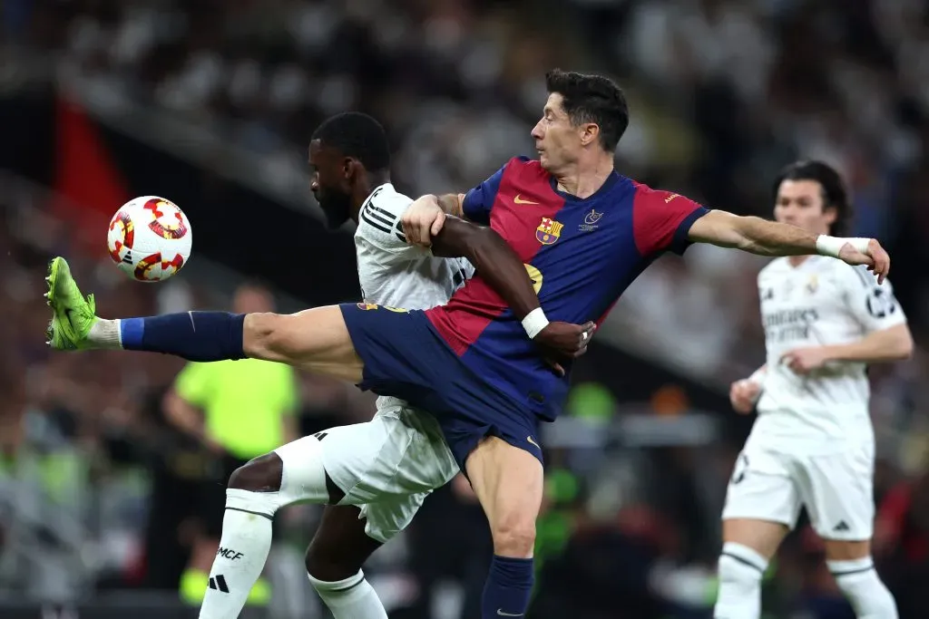 Robert Lewandowski, do FC Barcelona, disputa a posse de bola com Antonio RĂŒdiger, do Real Madrid (encoberto), durante a final da Supercopa da Espanha entre Real Madrid e FC Barcelona, na King Abdullah Sports City, em 12 de janeiro de 2025, em Jeddah, ArĂĄbia Saudita. (Foto de Yasser Bakhsh/Getty Images)