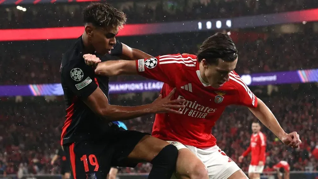 Lamine Yamal, do FC Barcelona, disputa a bola com Álvaro Carreras, do S.L. Benfica, durante a partida da 7ª rodada da fase de liga da UEFA Champions League 2024/25 entre SL Benfica e FC Barcelona, no Estádio do SL Benfica, em 21 de janeiro de 2025, em Lisboa, Portugal. (Foto de Carlos Rodrigues/Getty Images)
