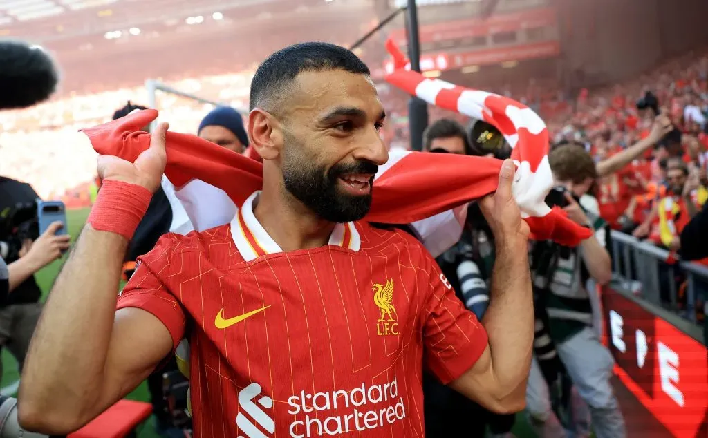 Salah, falou do treinador do Tottenham após titulo contra o Manchester United, com a bandeira do Liverpool e camisa vermelha
