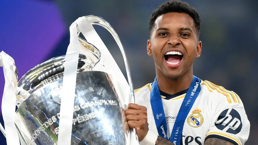 Rodrygo, com taça na mão, com a camisa branca do Real Madrid