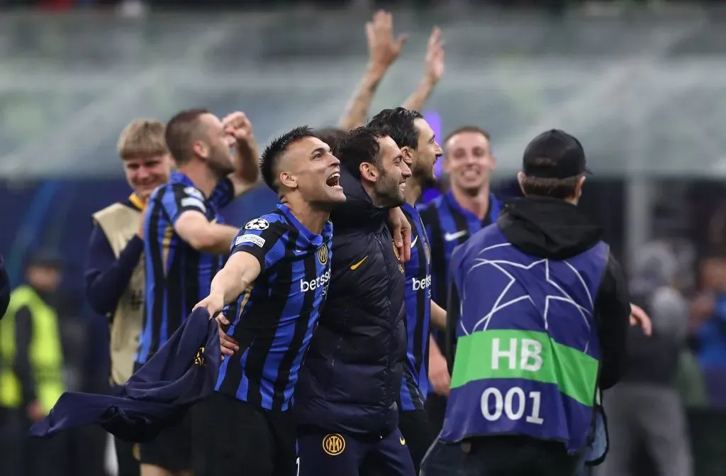Jogadores da Inter de Milão, em campo, com a camisa azul e preta, comemorando na Champions League
