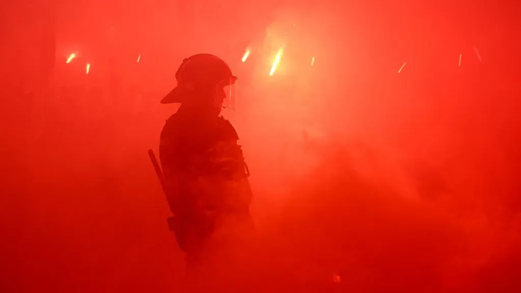 Policial no meio da torcida do PSG. Foto: David Ramos/Getty Images