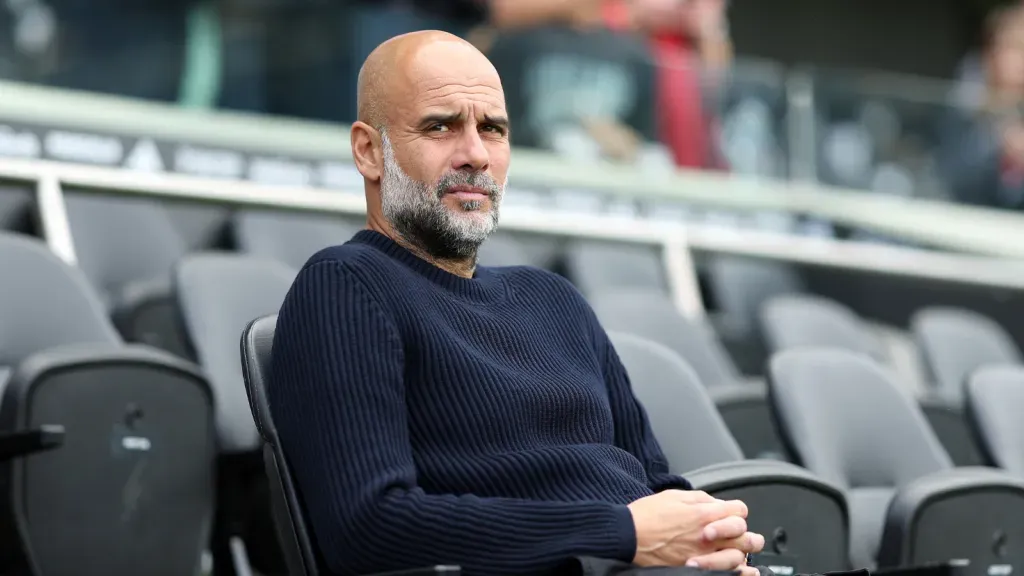 Guardiola, com olhar sério, durante jogo do Manchester City no banco de reservas (Photo by Alex Davidson/Getty Images)