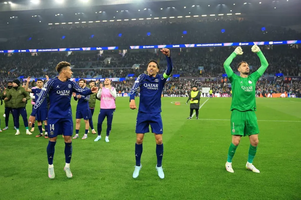 Desire Doue, Marquinhos e Gianluigi Donnarumma, do Paris Saint-Germain, comemoram após o apito final, após a vitória da equipe e a consequente classificação para a próxima fase da UEFA Champions League 2024/25, no jogo de volta das quartas de final contra o Aston Villa, realizado em 15 de abril de 2025, no Villa Park, em Birmingham, Inglaterra. (Foto: Carl Recine/Getty Images)