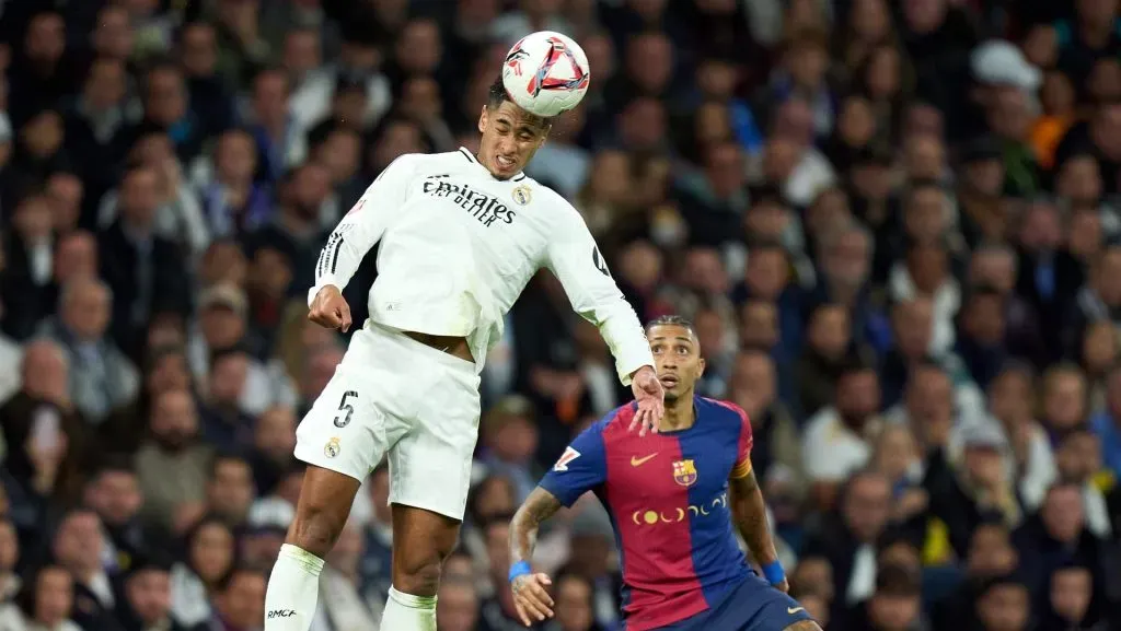 Jude Bellingham, do Real Madrid, cabeceia a bola enquanto é pressionado por Raphinha, do FC Barcelona, durante a partida da LaLiga entre Real Madrid CF e FC Barcelona, no Estádio Santiago Bernabéu, em 26 de outubro de 2024, em Madri, Espanha. (Photo by Angel Martinez/Getty Images)