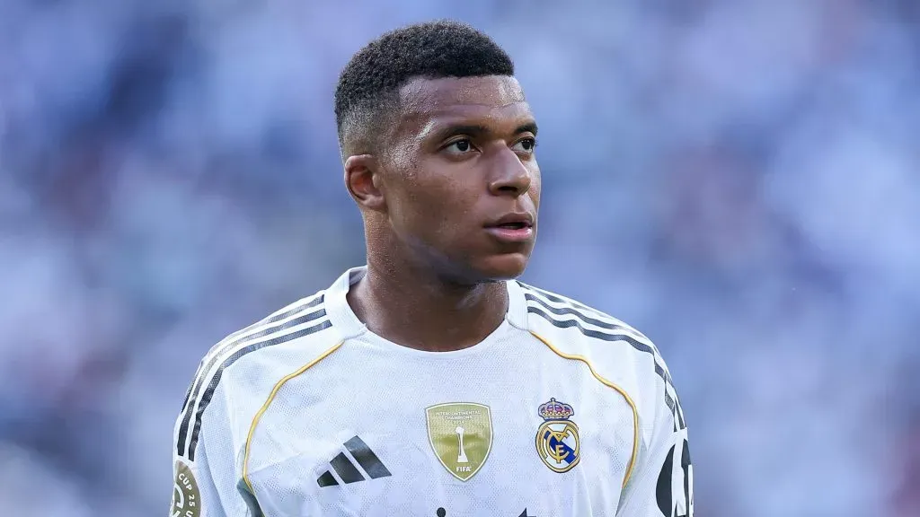 Mbappé, em campo, de camisa branca.
