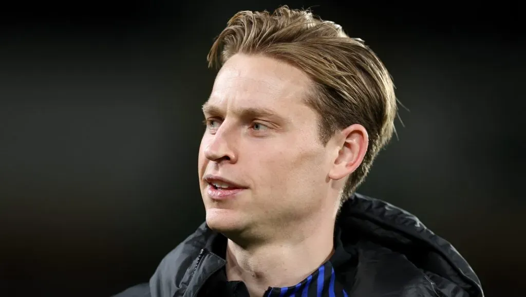 De Jong, com a jaqueta preta e camsa azul, em campo