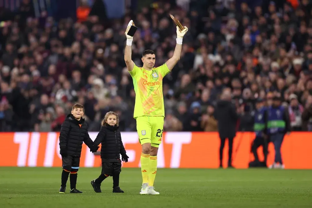 Emiliano Martinez, do Aston Villa, cumprimenta os fãs com seus filhos Santiago Martinez e Ava Martinez ao apresentar seus Troféus Yashin para as temporadas de 2023 e 2024, após se tornar o primeiro goleiro a ganhar um segundo e consecutivo Troféu Yashin no Ballon d’Or Awards em 28 de outubro de 2024, antes da partida da Fase MD5 da Liga dos Campeões da UEFA 2024/25 entre Aston Villa FC e Juventus no Villa Park em 27 de novembro de 2024 em Birmingham, Inglaterra. Foto: Ryan Pierse/Getty Images