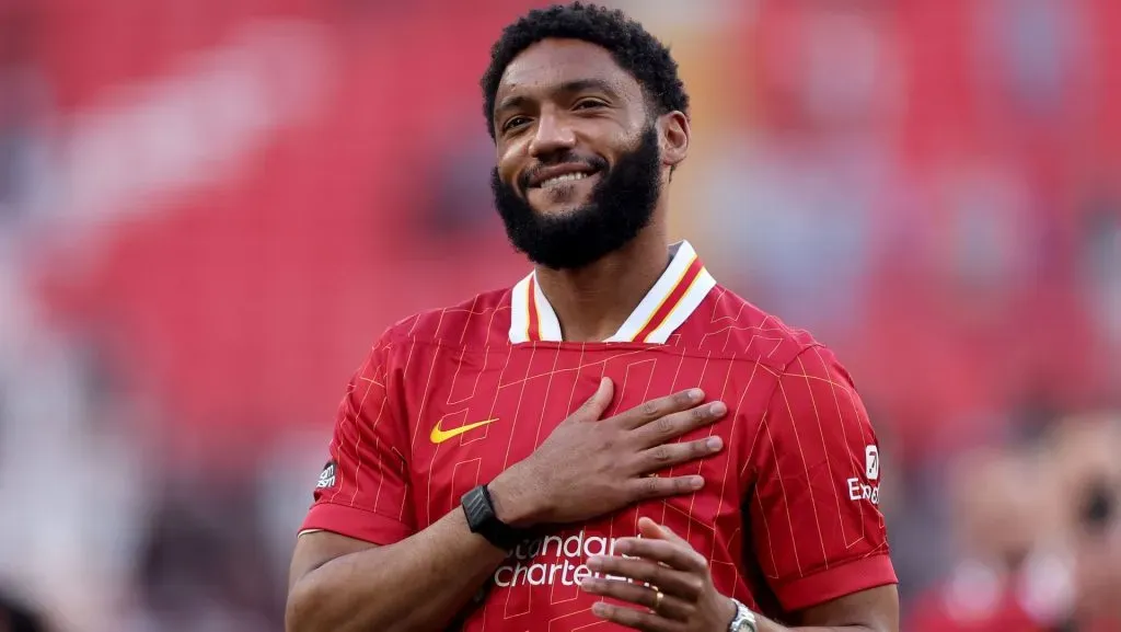 Joe Gomez veste a camisa vermelha do Liverpool. Com a mão no peito e um sorriso, o jogador agradece a torcida. Foto: Carl Recine/Getty Images