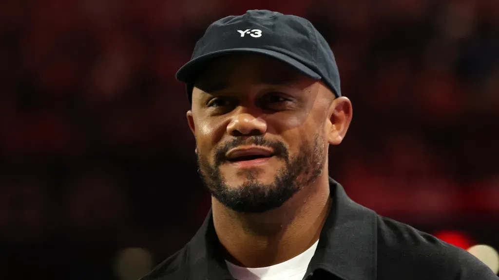 Vincent Kompany sorri de boné durante partida do Bayern de Munique. (Foto: Alexander Hassenstein/Getty Images)