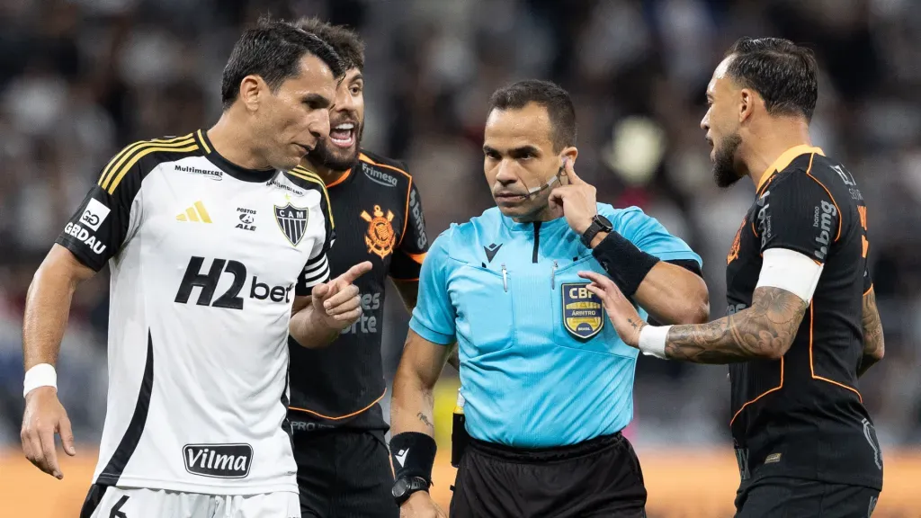 O árbitro Alex Gomes Stefano escuta o VAR durante partida entre Corinthians e Atlético-MG. (Foto: Joisel Amaral/AGIF)