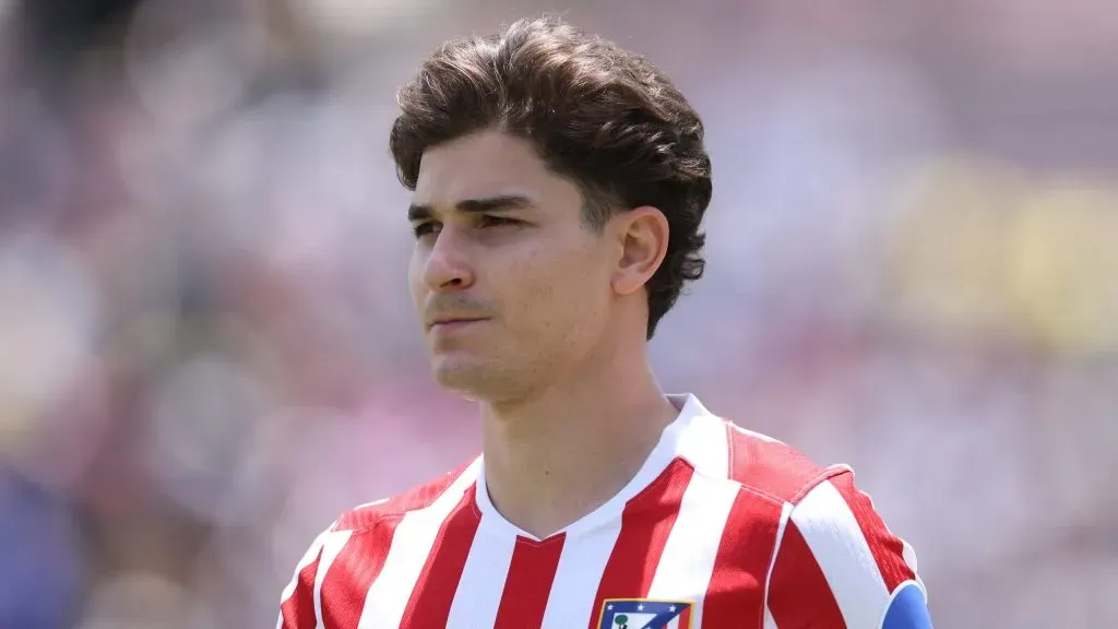 Julián Álvarez em campo e com uma expressão séria vestindo a camisa do Atlético de Madrid