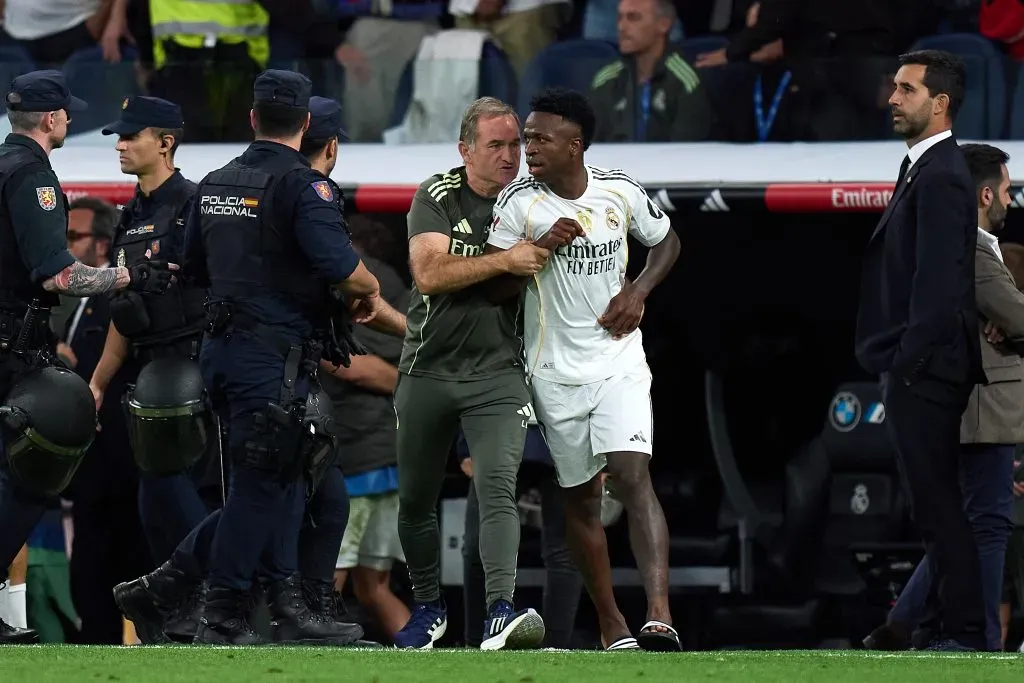 inicius Junior, do Real Madrid, é escoltado para fora do campo por Luis Llopis, treinador de goleiros do Real Madrid, após confusão com Lamine Yamal, do Barcelona, na partida da LaLiga entre Real Madrid CF e FC Barcelona, no Estádio Santiago Bernabeu, em 26 de outubro de 2025, em Madri, Espanha. (Foto de Angel Martinez/Getty Images)