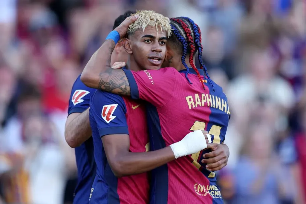 Lamine Yamal comemorando gol pelo Barcelona abraçado a Raphinha (Photo by Judit Cartiel/Getty Images)