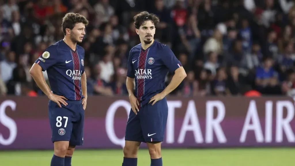 João Neves, camisa 87 do Paris Saint-Germain, e Vitinha, camisa 17 do Paris Saint-Germain, observam o jogo durante a partida da Ligue 1 entre Paris Saint-Germain e Angers SCO, no Parc des Princes, em 22 de agosto de 2025, em Paris, França. (Foto de Catherine Steenkeste/Getty Images para a Qatar Airways)
