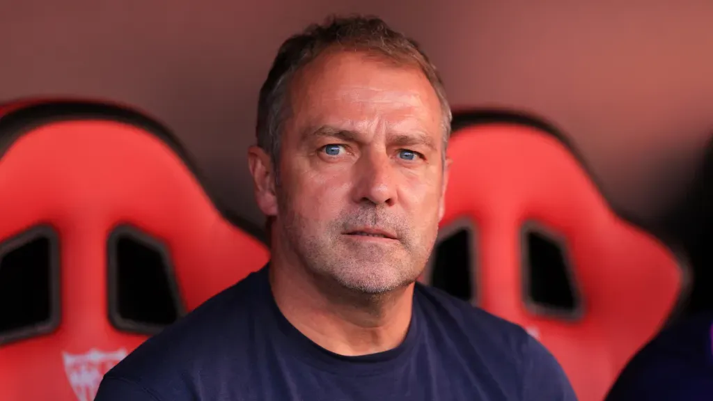 Hansi Flick sentado no banco de reservas durante partida do Barcelona. (Foto: Fran Santiago/Getty Images)