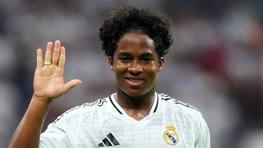 Endrick, com a mão levantada, em campo