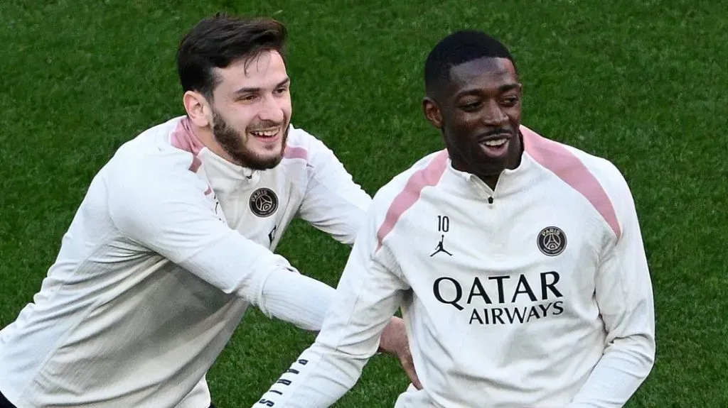 Kvaratskhelia e Dembélé, em campo, de camisa branca do PSG
