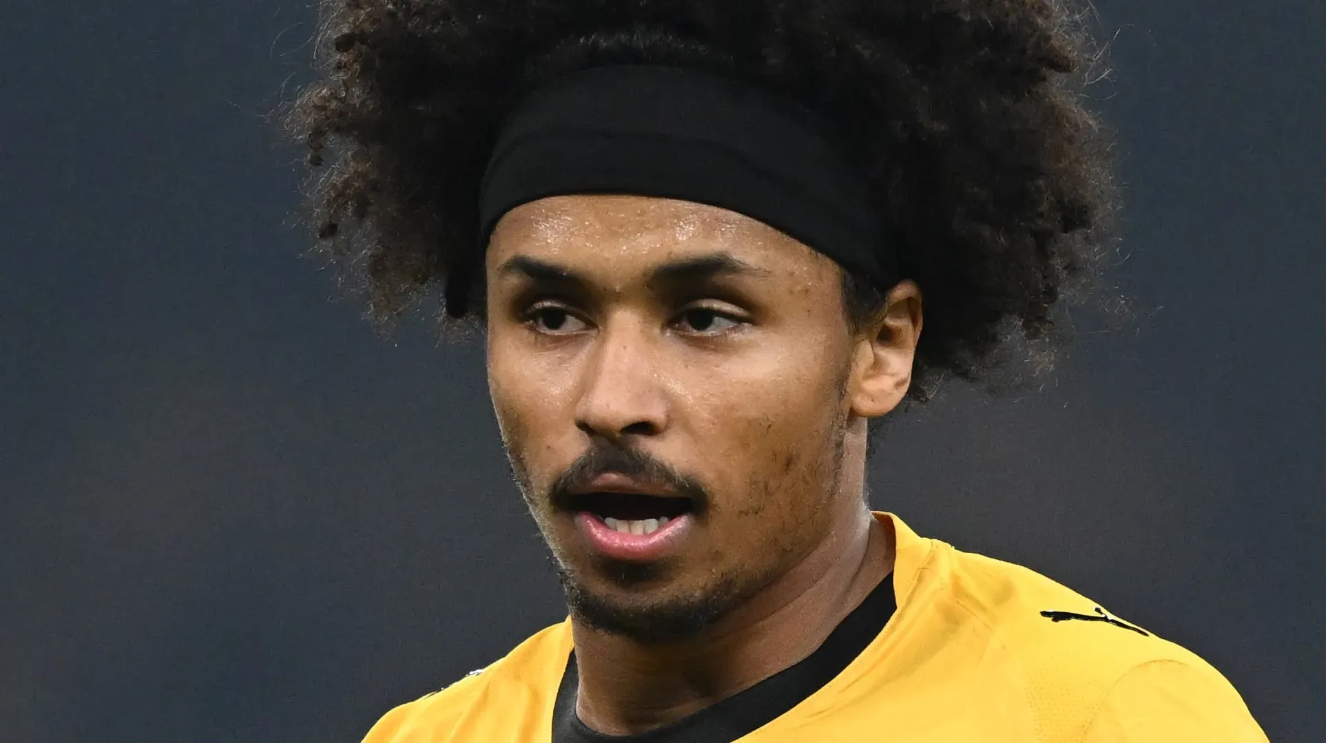 Adeyemi com olhar concentrado usando a camisa aurinegra do Borussia Dortmund