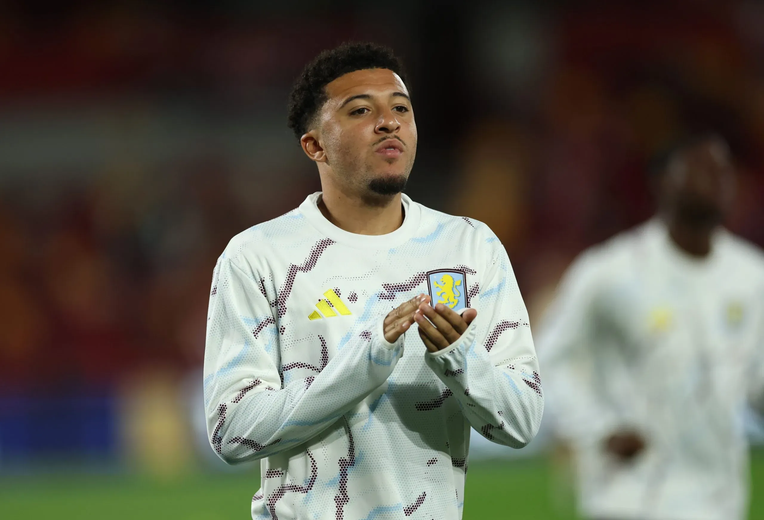 Sancho com camisa branca de treino durante aquecimento pelo Aston Villa (Photo by Eddie Keogh/Getty Images)