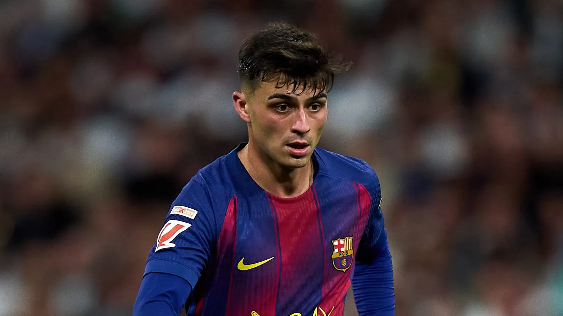 Pedri conduzindo a bola com o uniforme blaugrana do Barcelona