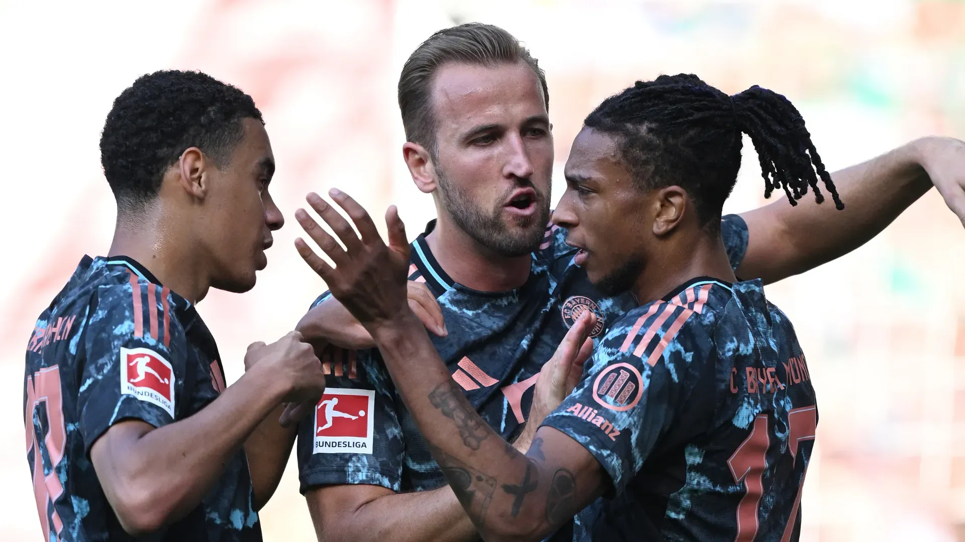 Olise, Jamal Musiala e Harry Kane comemorando gol com a camisa do Bayern de Munique