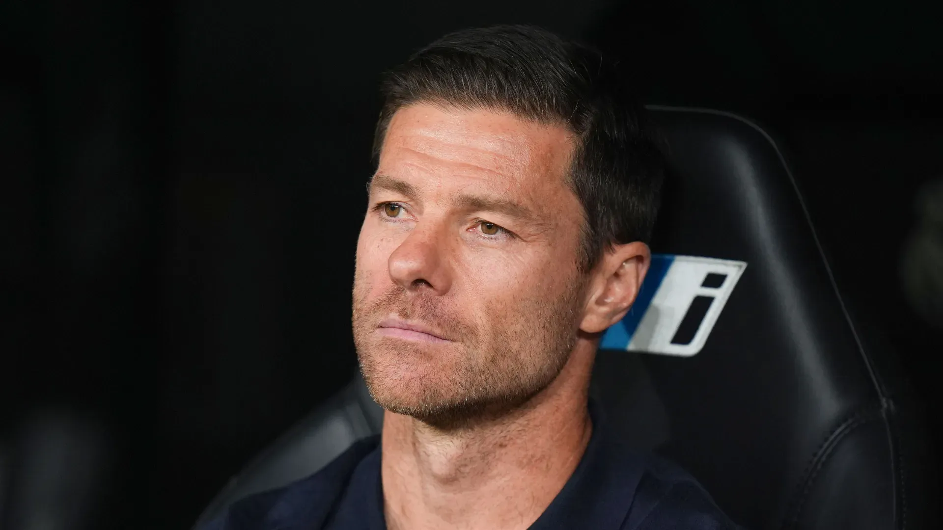 Xabi Alonso sentado no banco de reservas durante jogo do Real Madrid