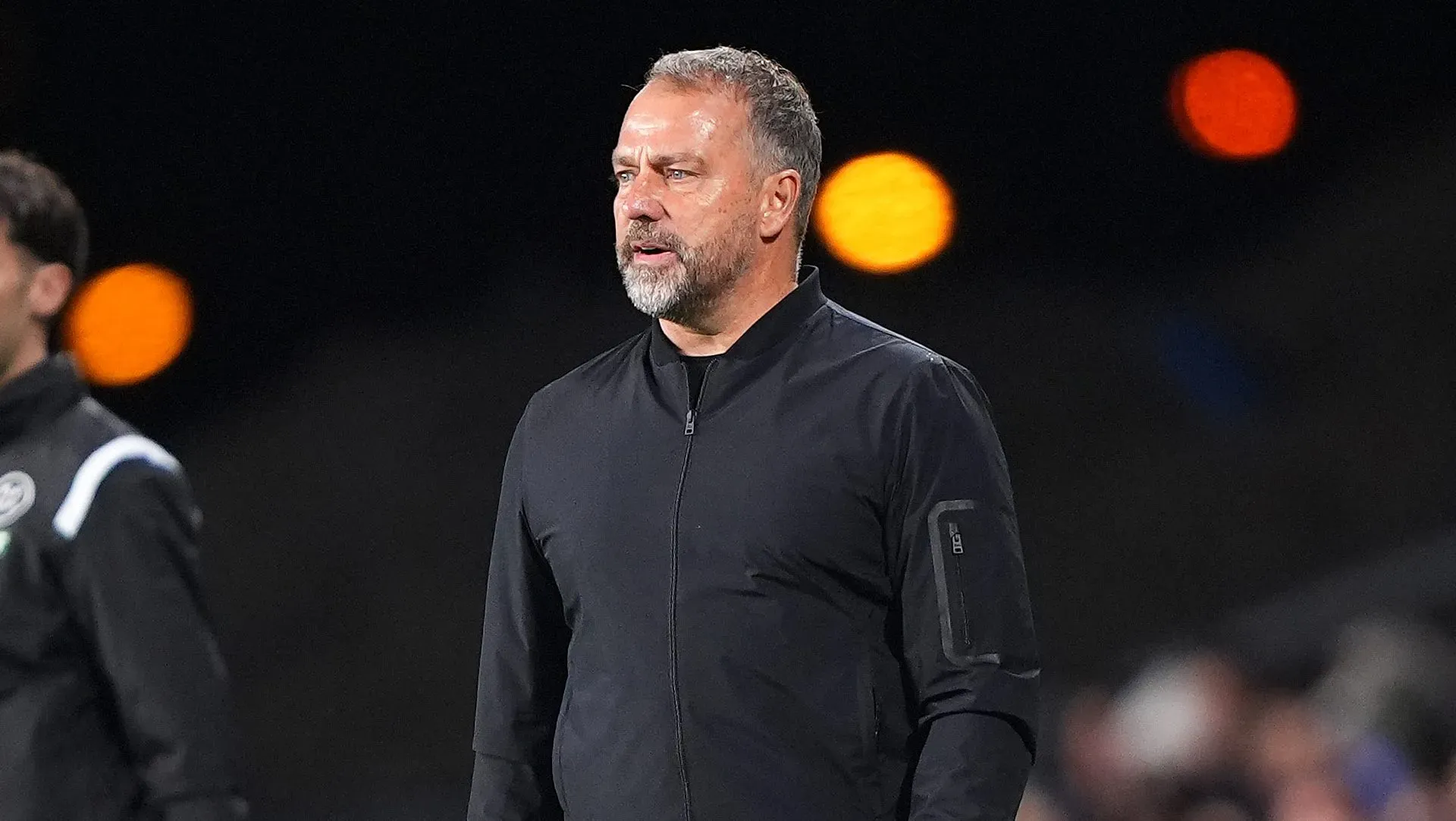 Hansi Flick vestido de preto na área técnica do Barcelona