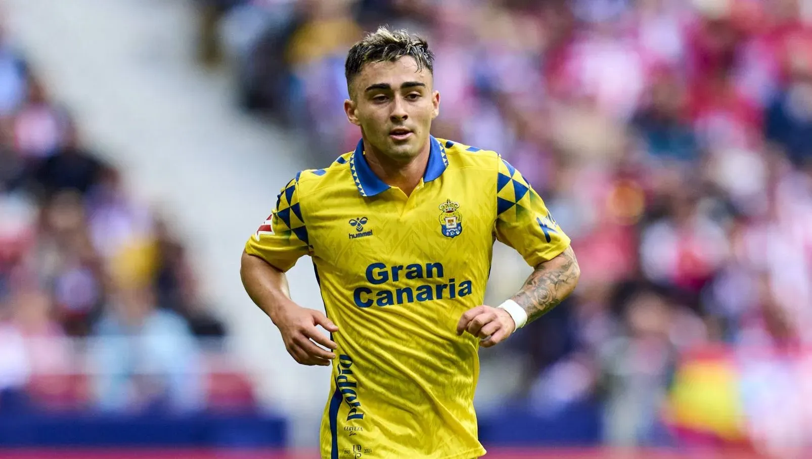 Alberto Moleiro correndo em campo com a camisa tradicional do Las Palmas (IMAGO Pressinphoto)