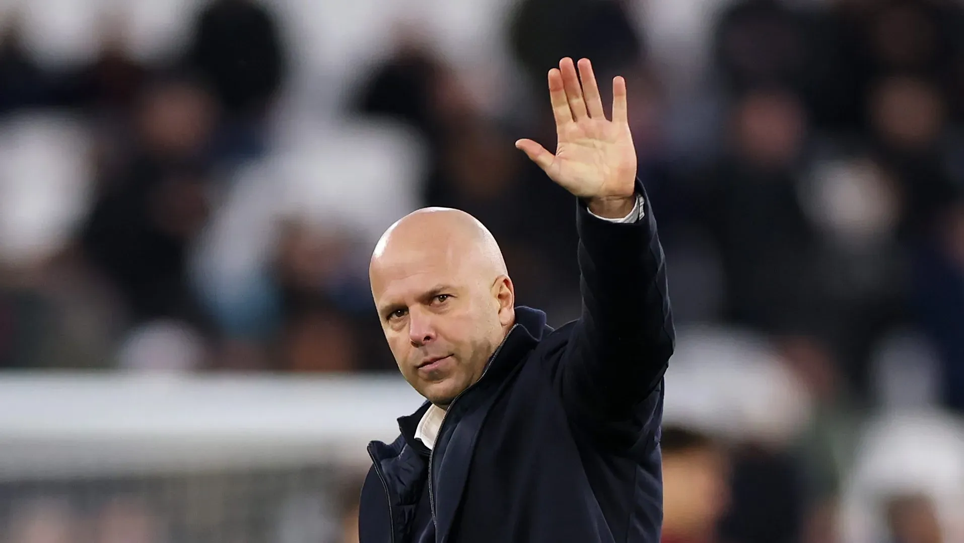 Arne Slot acenando ao lado de Szoboszlai com a camisa alternativa do Liverpool