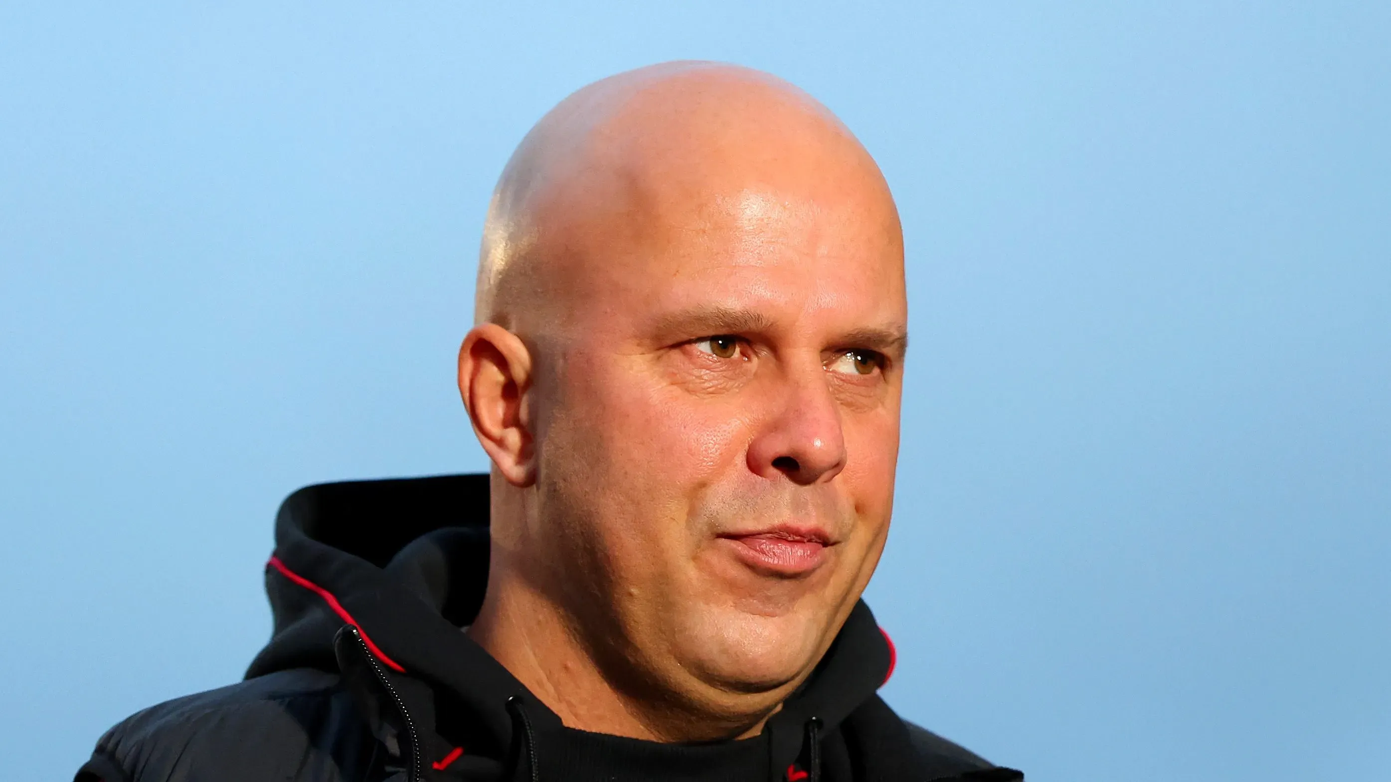 Arne Slot com cara de dúvida vestindo um agasalho preto