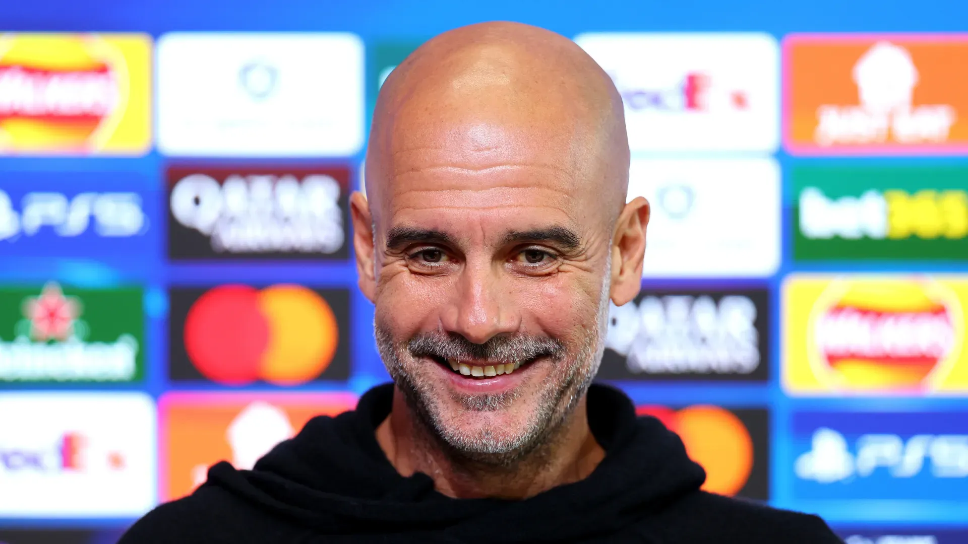 Pep Guardiola sorri durante entrevista coletiva do Manchester City