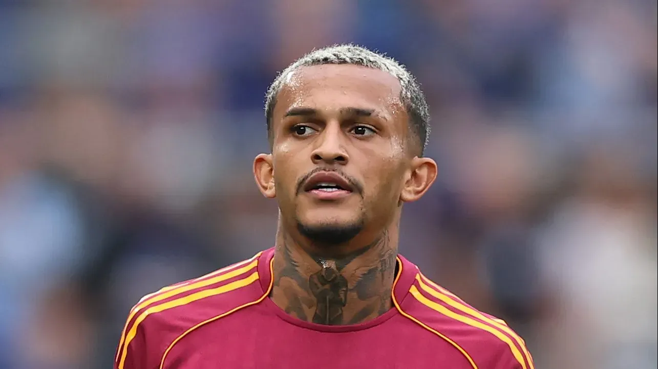 Wesley olhando para o lado vestindo a camisa principal da Roma