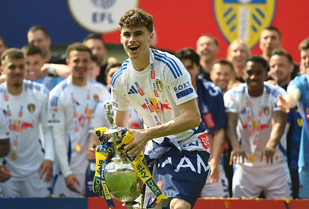 Harry Gray, do Leeds United, comemora com o troféu do Sky Bet Championship após a vitória da equipe por 2 a 1, que confirmou o título e o acesso à Premier League. A vitória veio após a partida entre Plymouth Argyle FC e Leeds United FC, realizada no Home Park, em 3 de maio de 2025, em Plymouth, Inglaterra. (Foto de Harry Trump/Getty Images)