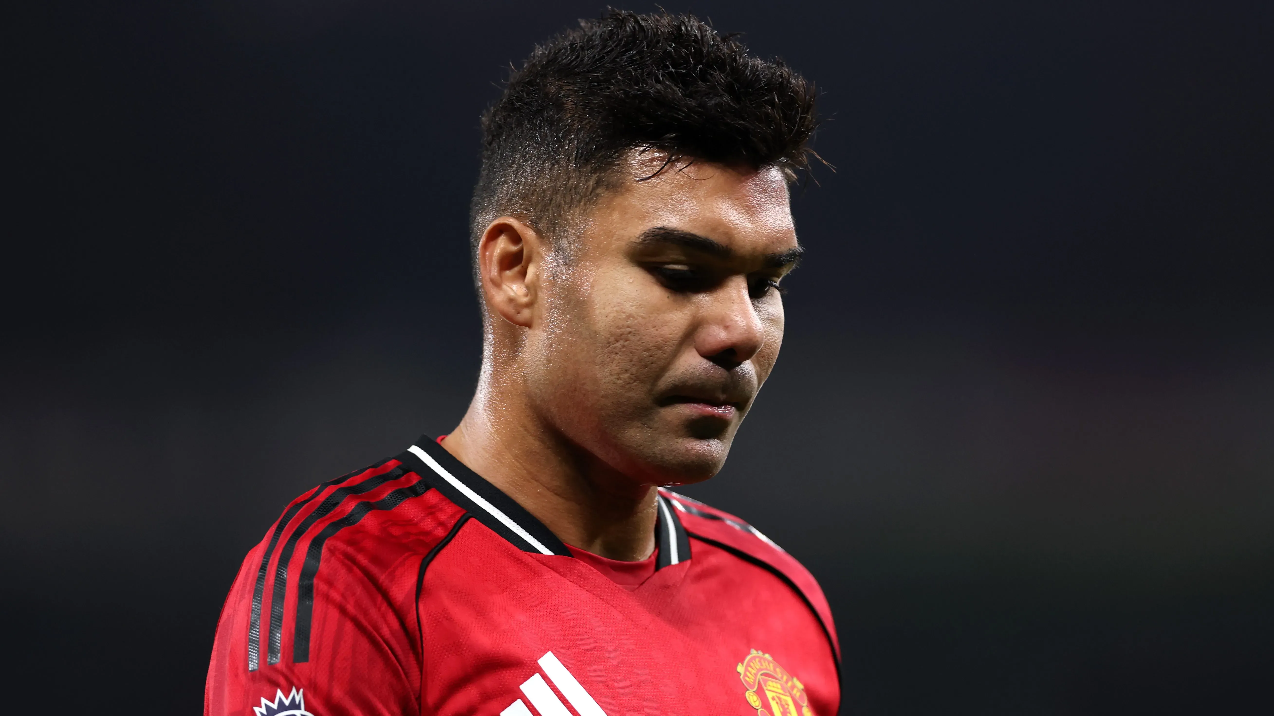 Casemiro de cabeça baixa, usando camisa vermelha do Manchester United. Foto: Justin Setterfield/Getty Images